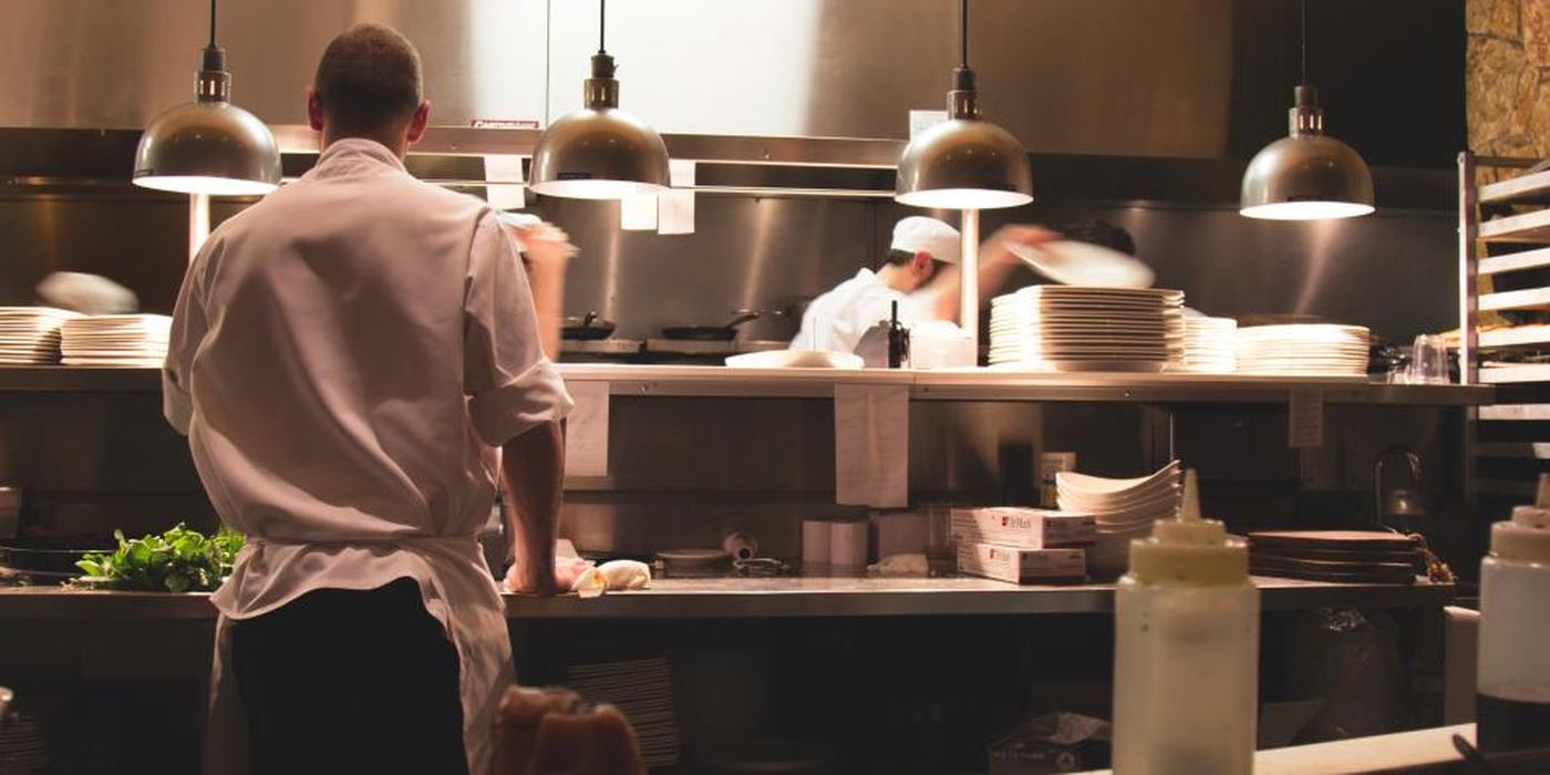 Küchenpass eines Restaurants am Abend, warme Hängeleuchten über der Ausgabe