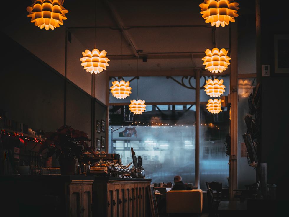Warm beleuchtetes Lokal von innen, Blick zum Fenster in der Dämmerung